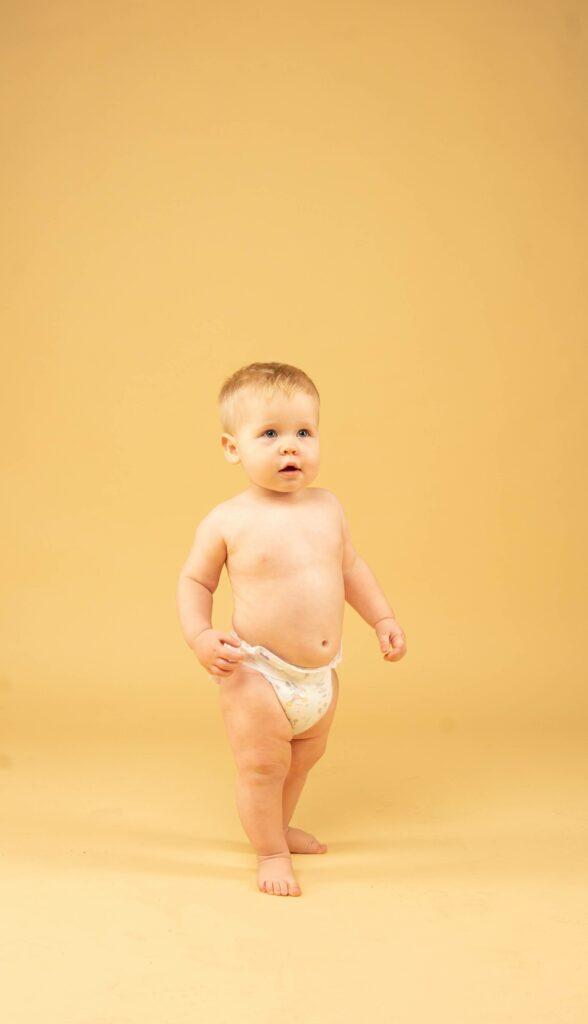 Adorable baby standing with the diaper
