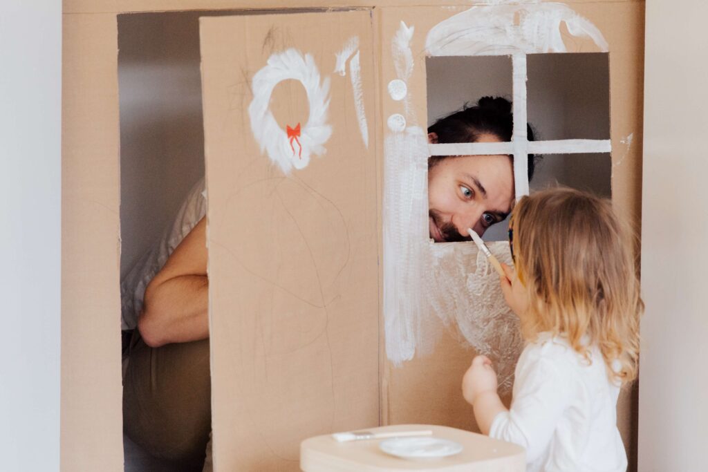father and daughter play inside a toy house